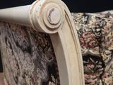 a close up of a chair with a floral upholstered back