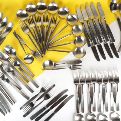de nombreuses cuillères et fourchettes disposées sur une table