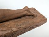 a statue of a person holding a baseball bat on a white surface