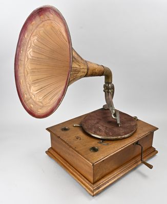 un vieux gramophone posé sur un support en bois, sur fond blanc