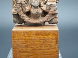 une image représentant une sculpture d'un homme et d'une femme sur un bloc de bois