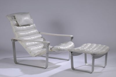 a white leather chair and ottoman in a white room