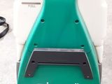 an image of a green and white floor scruber sitting on the ground