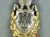 an image of a silver and gold medal with a black eagle on it