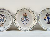trois assiettes à motifs posées sur une surface blanche
