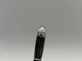 a close up of a pen on a white surface with a gray background