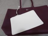 the large white purse is sitting on top of a purple bag