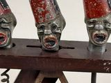 three red and black masks on top of a wooden stand