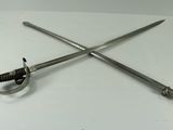two swords on a white table with a pair of scissors