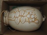 un vase blanc dans une boîte décorée de fleurs peintes