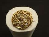 Gros plan sur une bague en or ornée de pierres roses