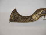 an old brass pistol with a wooden handle on a white surface