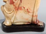 a figurine of a woman sitting on a chair