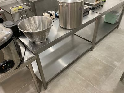 many pots and pans sitting on a stainless steel table