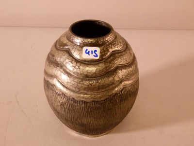 un vase en argent muni d'une étiquette, posé sur une table