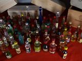 many bottles of alcohol on a table with a red cloth
