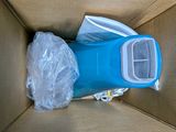 a blue trash can in a cardboard box with plastic wrap around it