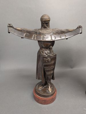 statue en bronze représentant un homme tenant une épée, posée sur un socle en bois