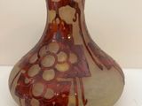un vase brun et blanc posé sur une table blanche
