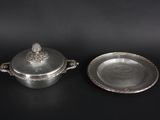 a pair of silverplated dishes on a black surface