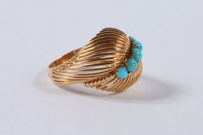Gros plan sur une bague en or ornée de turquoises