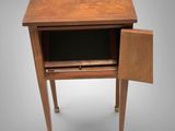 a small wooden table with a drawer on top of it