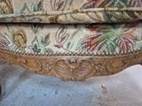 a close up of a chair with a floral upholstered
