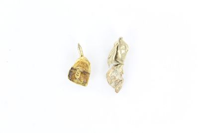 deux breloques en feuille d'argent et d'or sur un fond blanc