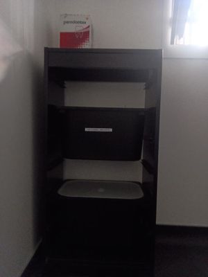 une étagère noire sur laquelle est posé un ordinateur portable
