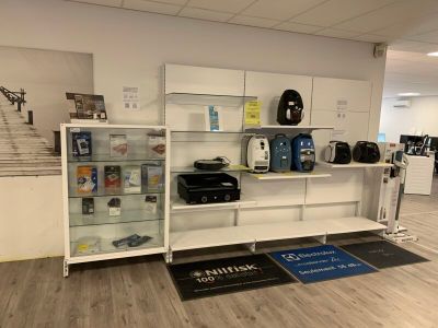 une vitrine au milieu d'une pièce, sur laquelle sont posés des bagages