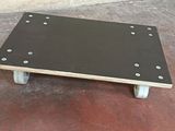 a small wooden table with wheels on a concrete floor