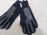 pair of black leather gloves on a white surface with a zipper