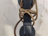 une corde enroulée autour d'un téléphone fixé au mur sur un poteau