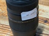 a camera lens on a wooden table with a tag on it