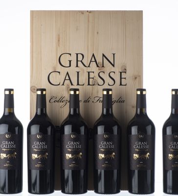 six bouteilles de Gran Calesse sont alignées devant une caisse en bois
