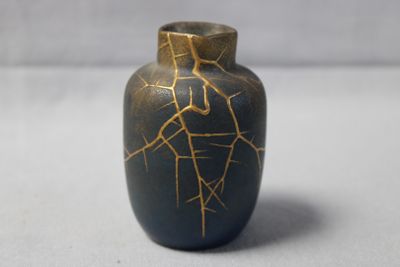 a small vase that has a cracky surface on it