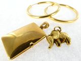gold plated elephant locke and ring set on a white surface