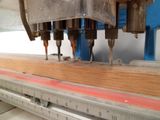 une machine qui coupe une pièce de bois sur une table