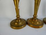 three brass candlesticks sitting on a white surface