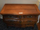 a wooden chest of drawers in a corner of a room