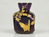 a purple vase with a gold leaf design on it