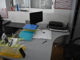 a desk with a computer, printer and other office supplies on it