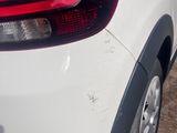 a white car that is parked on the side of the road