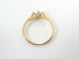 a close up of a gold ring with a pearl on it