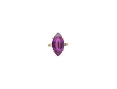 a close up of a purple stone ring on a white surface