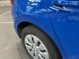 a close up of a blue car parked in a parking lot