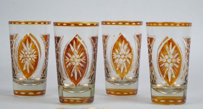 quatre verres à shot sont alignés sur une surface blanche