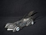 a toy batmobile that is sitting on a black surface
