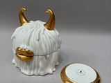 a white and gold ceramic object with horns on it