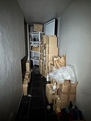 un couloir où se trouvent des cartons et d'autres objets par terre